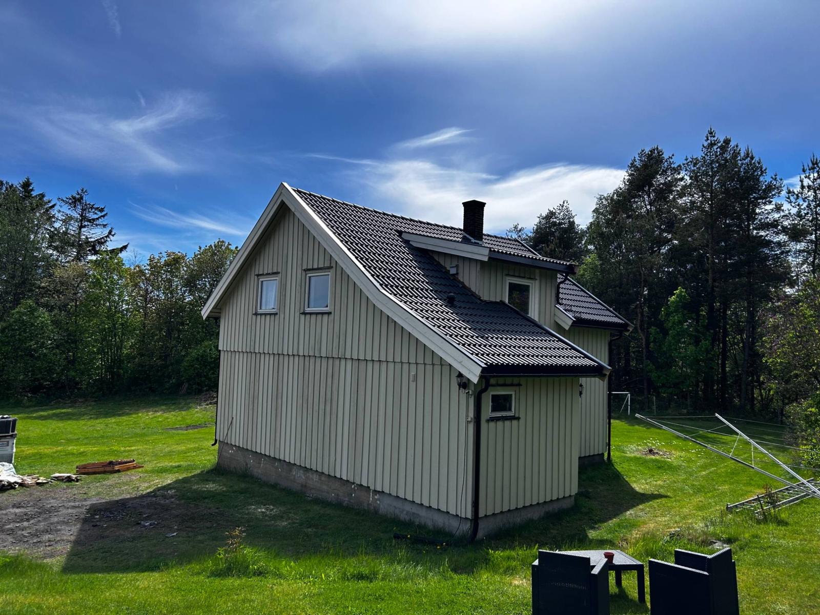 Lysegrønn bolig med nytt sort tak etter takomlegging